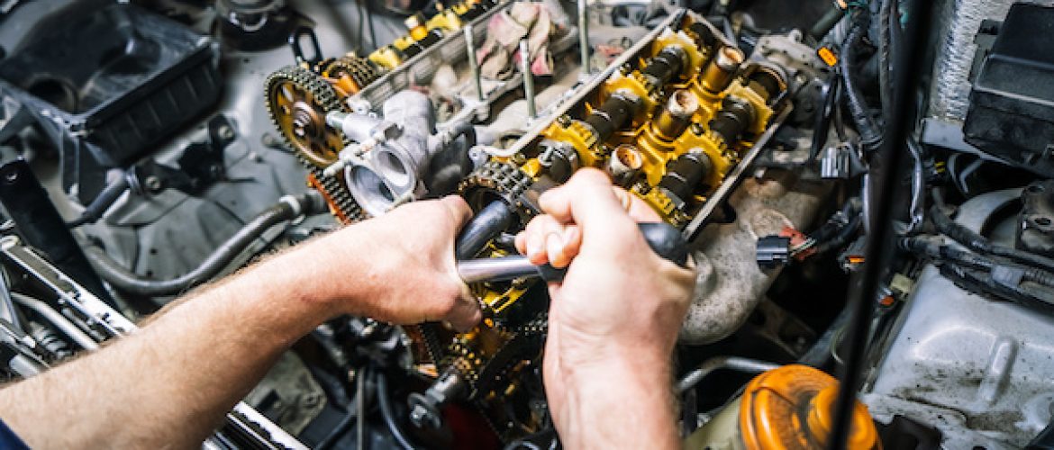 Car repair: overhaul of the V6 engine with detailed pulleys and parts. Close-up of hands.